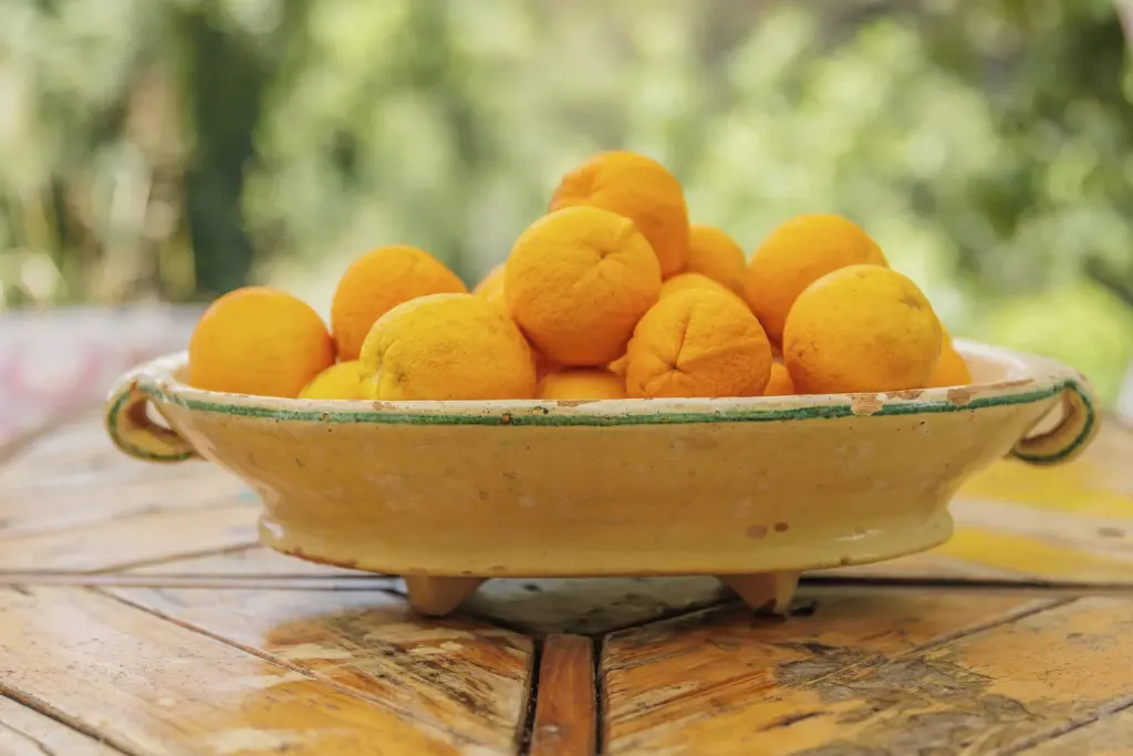 Cuenco de naranjas de la huerta sobre la mesa de madera